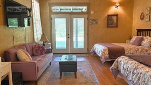 Una habitación acogedora con sofá, cama, una mesita y televisión.