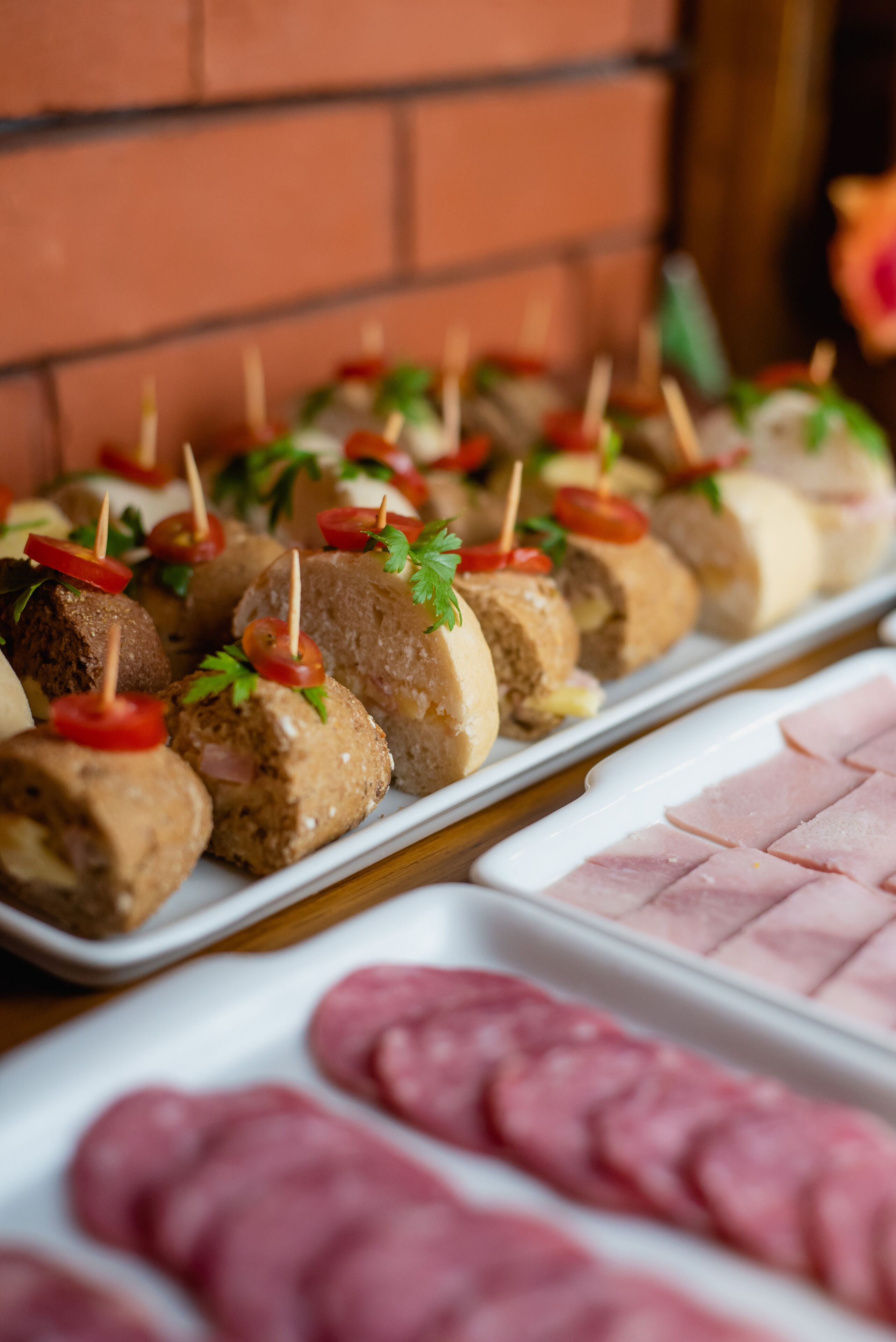 Una bandeja de comida, con albóndigas y jamón en rodajas, dispuesta sobre un plato blanco.