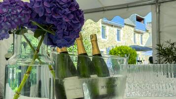 A glass container with champagne bottles and purple flowers.