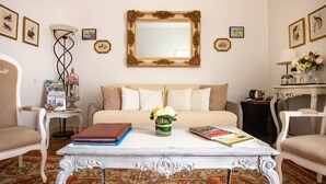 Un salon chaleureux avec un canapé, deux fauteuils, une table basse et un miroir décoratif.