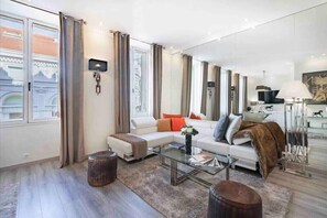 Relax in this stylish living room with a large window, comfortable sofa, and cozy throw blanket.