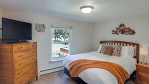 A bedroom with a bed, a dresser, a television, a window, and a ceiling light. - Dolores Ranch Cabin w/ Hot Tub & 1-Acre Yard! (Dolores)