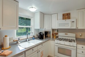 A kitchen with white cabinets, a stainless steel sink, a coffee maker, and a stove. - Dolores Ranch Cabin w/ Hot Tub & 1-Acre Yard! (Dolores)