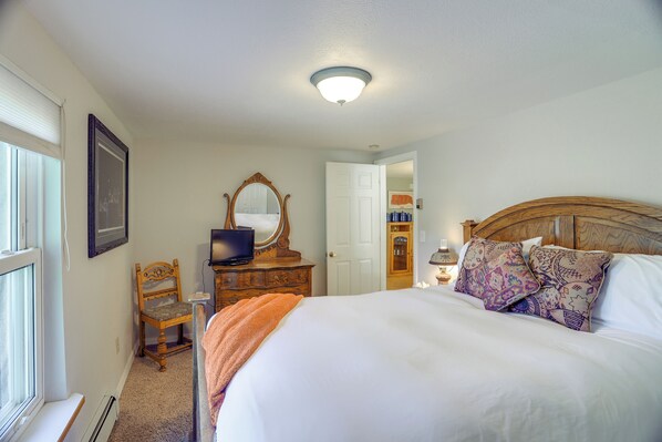 A bedroom with a bed, a dresser, a chair, a television, and a mirror. - Dolores Ranch Cabin w/ Hot Tub & 1-Acre Yard! (Dolores)