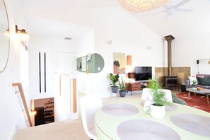 A modern living room with a dining area, a fireplace, and a TV. - Private 800 sq. ft. Suite in Nature Right by the Road to Mt. Bachelor Ski Resort (Bend)