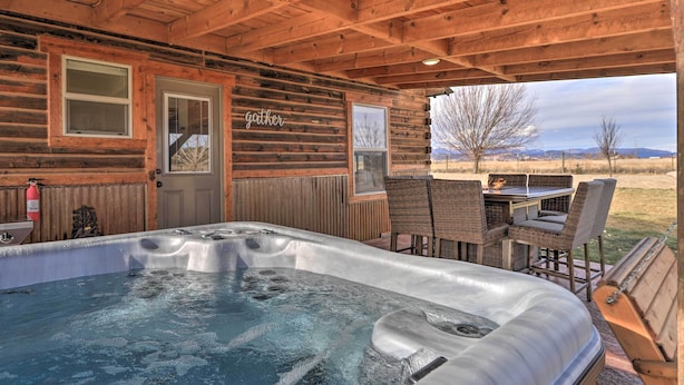 Een houten hut met een jacuzzi, buiten zitplaatsen en uitzicht op het landschap.