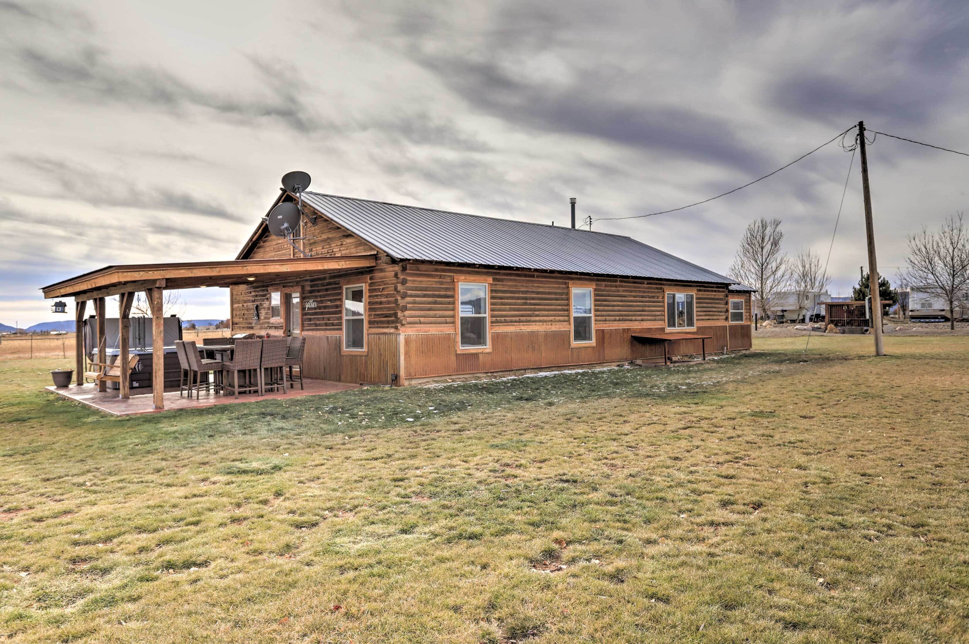 A wooden log cabin with a covered patio and a metal roof.