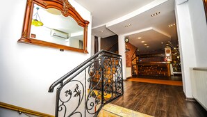 A staircase with ornate metal railings and a large mirror on the wall. - Villa Hotel Tbilisi (თბილისი)