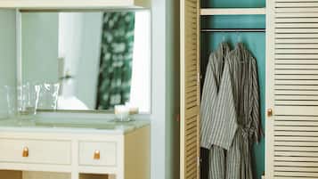 A bathroom with a mirror, a sink, and a towel rack with towels.