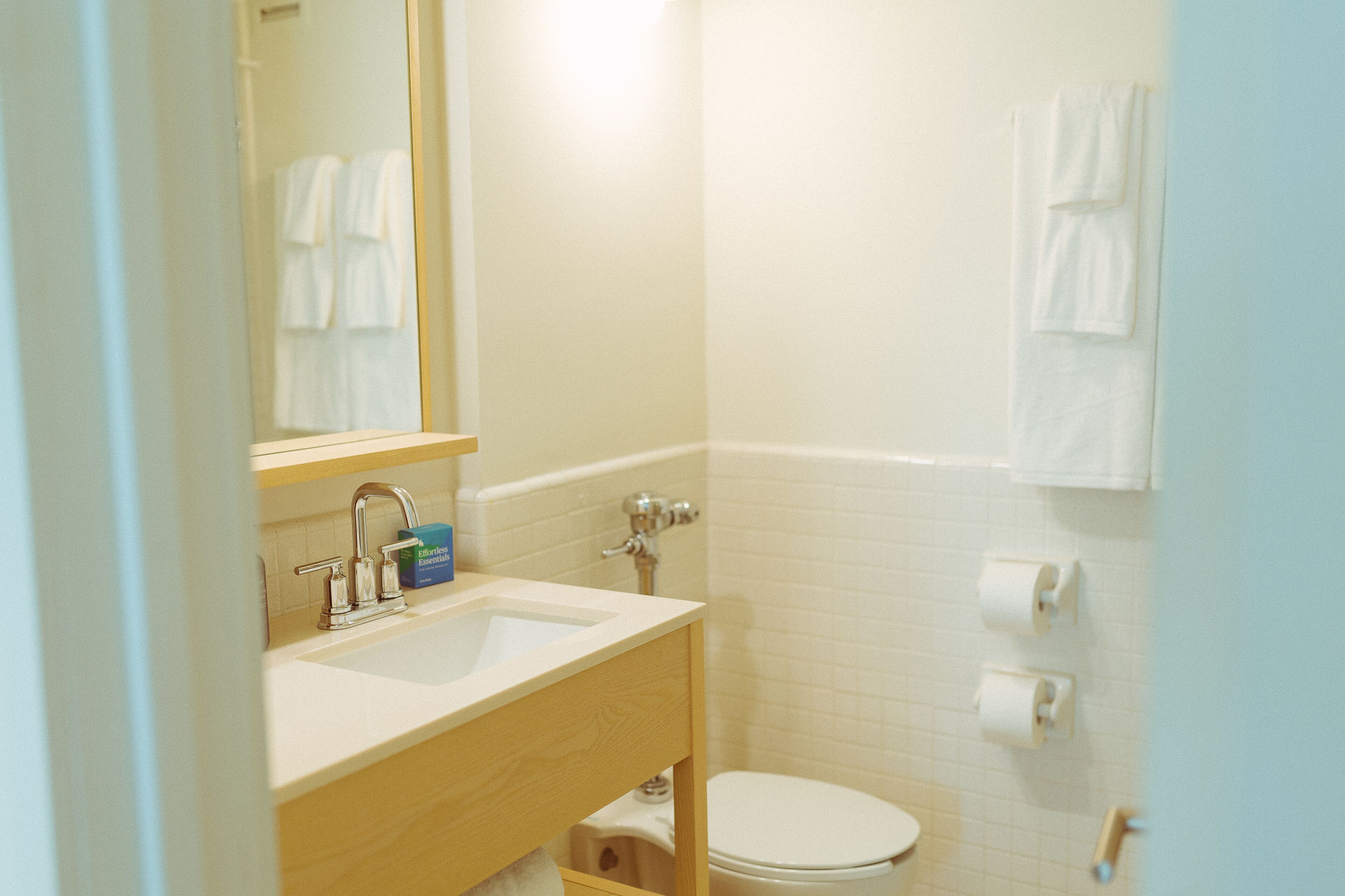 Un baño con lavabo, espejo e inodoro.