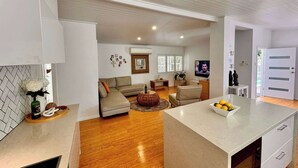 Una sala de estar moderna con un sofá, una mesa de centro y un televisor.