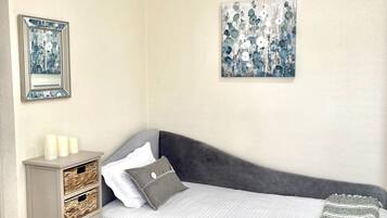 A bedroom with a bed, bedside table, and a wardrobe.