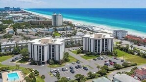 Eine Küstenlandschaft mit modernen Gebäuden, einem Parkplatz und freiem Blick auf Strand und Meer.