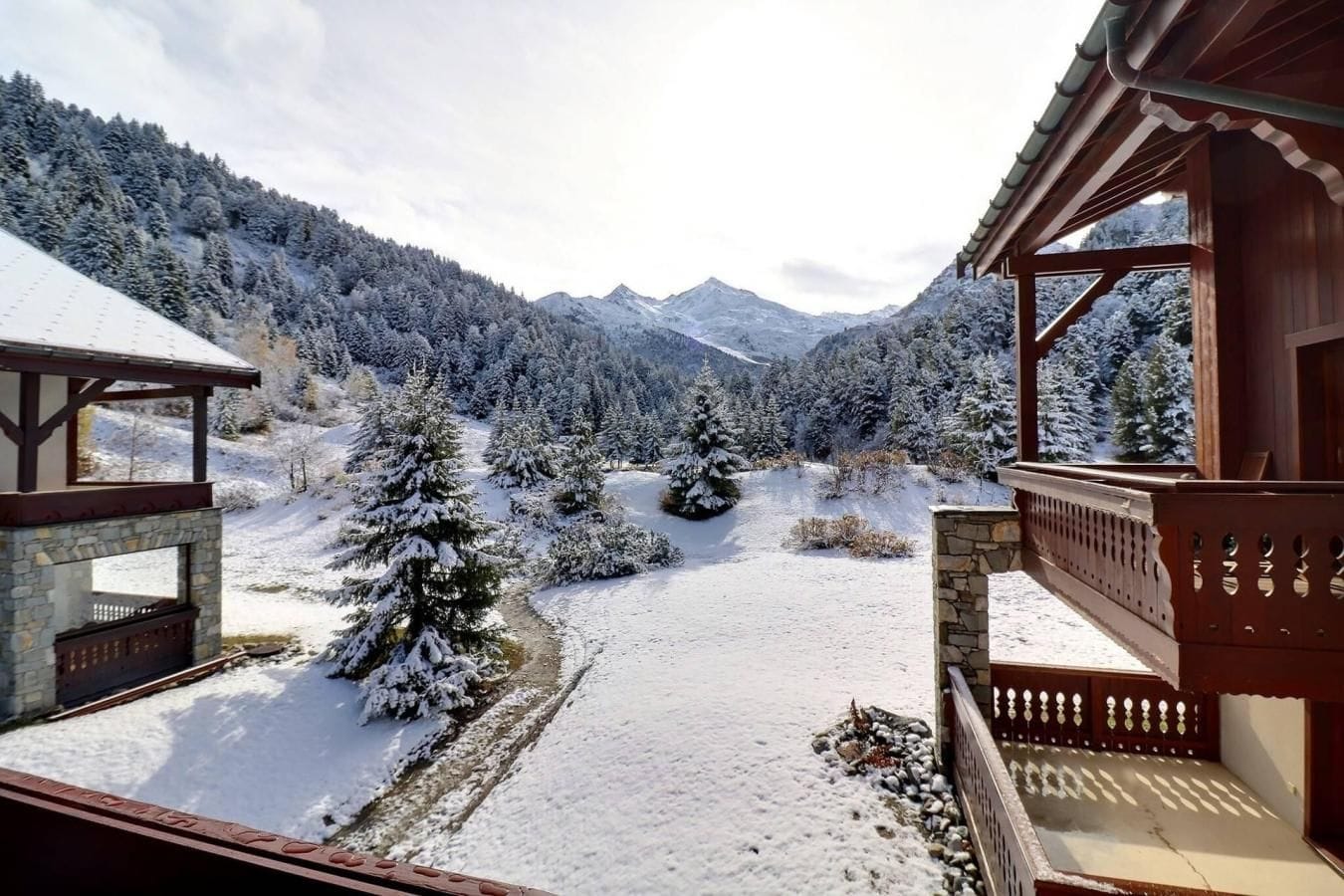 Paesaggio innevato con un edificio in legno dotato di balcone.