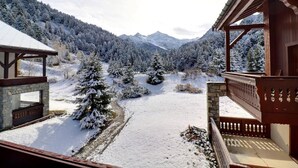 A snow-covered landscape with a wooden building featuring a stone foundation and a balcony. - 250m from ski slopes, 2nd floor, ski locker, 38m², Méribel-Mottaret (Méribel - Les Allues)