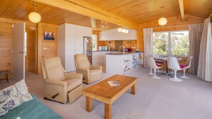 L’intérieur d’un chalet en bois chaleureux et accueillant, comprenant un espace de vie, une cuisine et un coin repas.