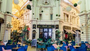 Un cafè amb un interior clàssic, amb caires verds i blaus, un menú a la pissarra i un cartell que diu "Bemoelle Cafe".