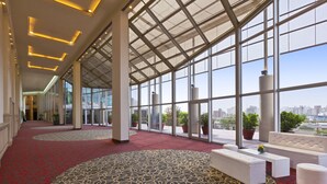 A spacious lobby with a red carpet, large windows, and a high ceiling. - Quinto Centenario Hotel (Córdoba)