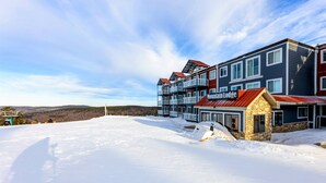 A multi-story hotel with a stone foundation and a red roof.