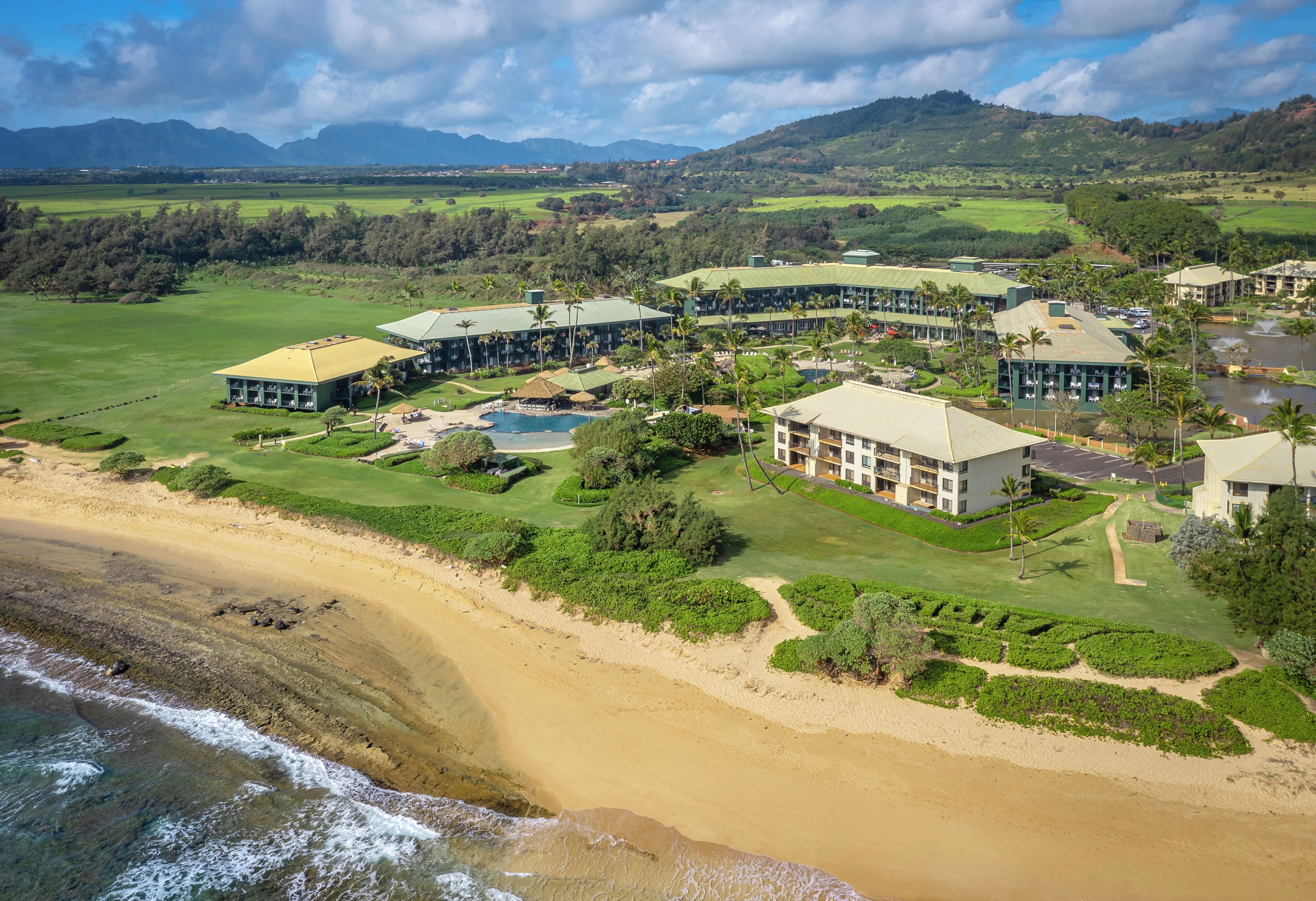 A resort with multiple buildings, a golf course, and a beach.