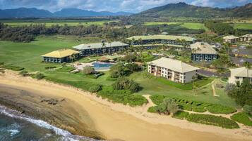 A resort with multiple buildings, a golf course, and a beach.