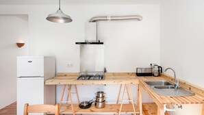 A compact kitchen with a wooden countertop, a gas stove, a sink, and a built-in oven. - Quiet and bright village house (Silves)