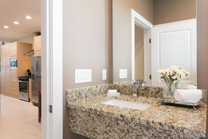 Bathroom features a granite countertop, large mirror, and a bathtub.