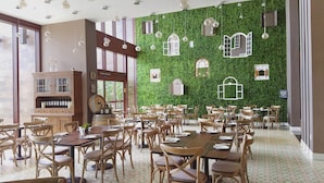 Ein Restaurant mit grüner Wand, Holzmöbeln und einer Weinauslage.