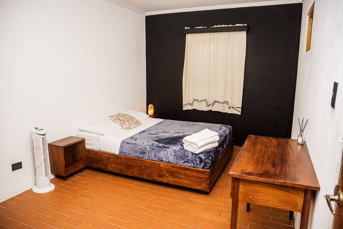 Ein Schlafzimmer mit Bett, Nachttisch und einem Heizkörper.