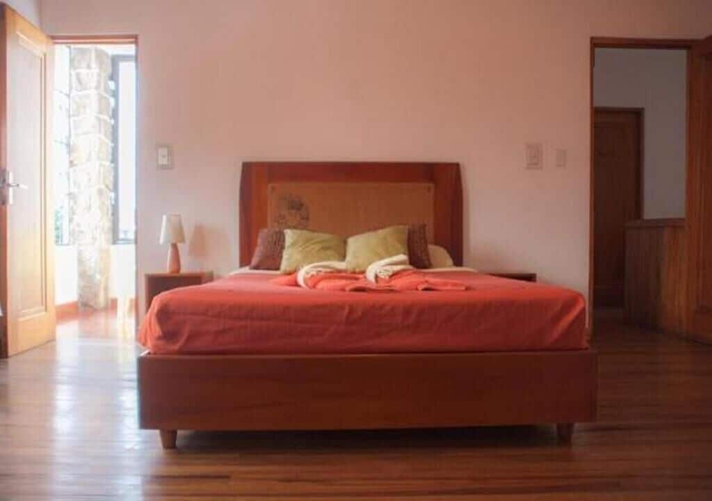 Ein Schlafzimmer mit einem Holzbett, einem Nachttisch und einer Lampe.