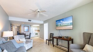 A modern living room with a sofa, a coffee table, and a TV mounted on the wall. - Phoenix I 1085 (Orange Beach)