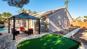 A house with a swimming pool, patio furniture, and a covered outdoor seating area. - Modern and Bright Resort Style Home w/Heated Pool (Las Vegas)