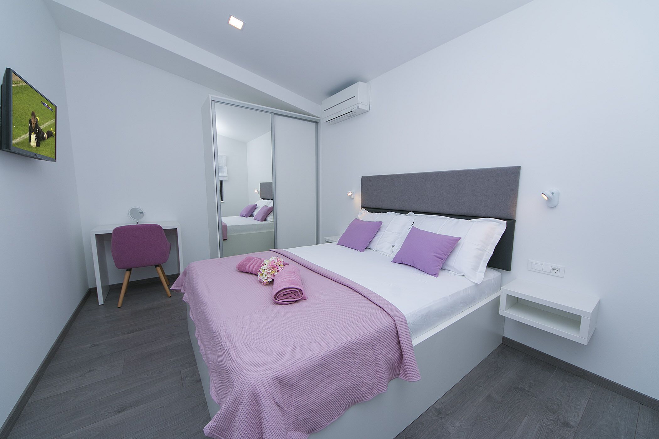 Ein modernes Schlafzimmer mit Bett, Schreibtisch und Stuhl.
