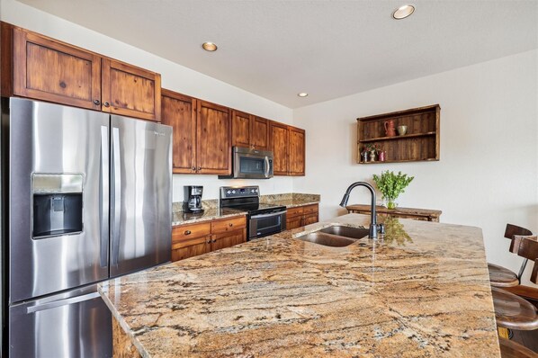 Enjoy cooking in this well-equipped kitchen with an oven, refrigerator, and microwave.