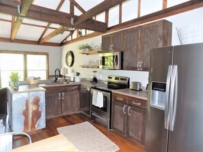 Une cuisine avec des meubles en bois, des appareils électroménagers en acier inoxydable et une grande fenêtre.