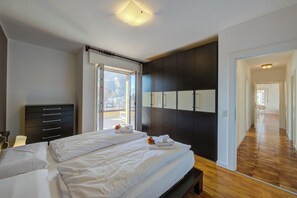 Quarto com cama, penteadeira, janela e vista para o exterior.