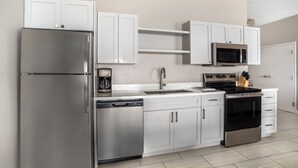 A modern kitchen with stainless steel appliances, white cabinetry, and a dishwasher. - Hilton Vacation Club Bayside Resort Panama City Beach (Panama City Beach)