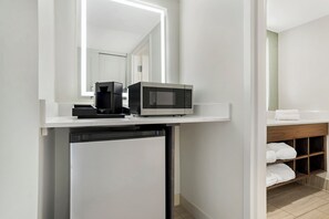 A compact kitchenette with a microwave, coffee maker, and a dishwasher.