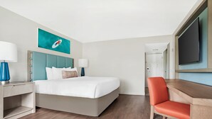 A hotel room with a bed, a desk, a chair, a television, and a painting on the wall. - Hilton Vacation Club Bayside Resort Panama City Beach (Panama City Beach)