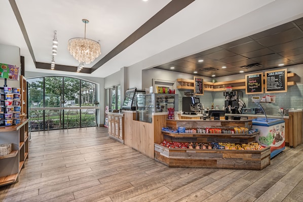 A modern cafe interior with a wooden counter, seating area, and a view of the outdoors.
