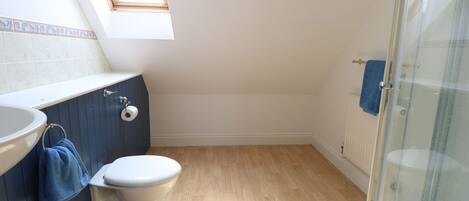 Een badkamer met toilet, wastafel en douche.