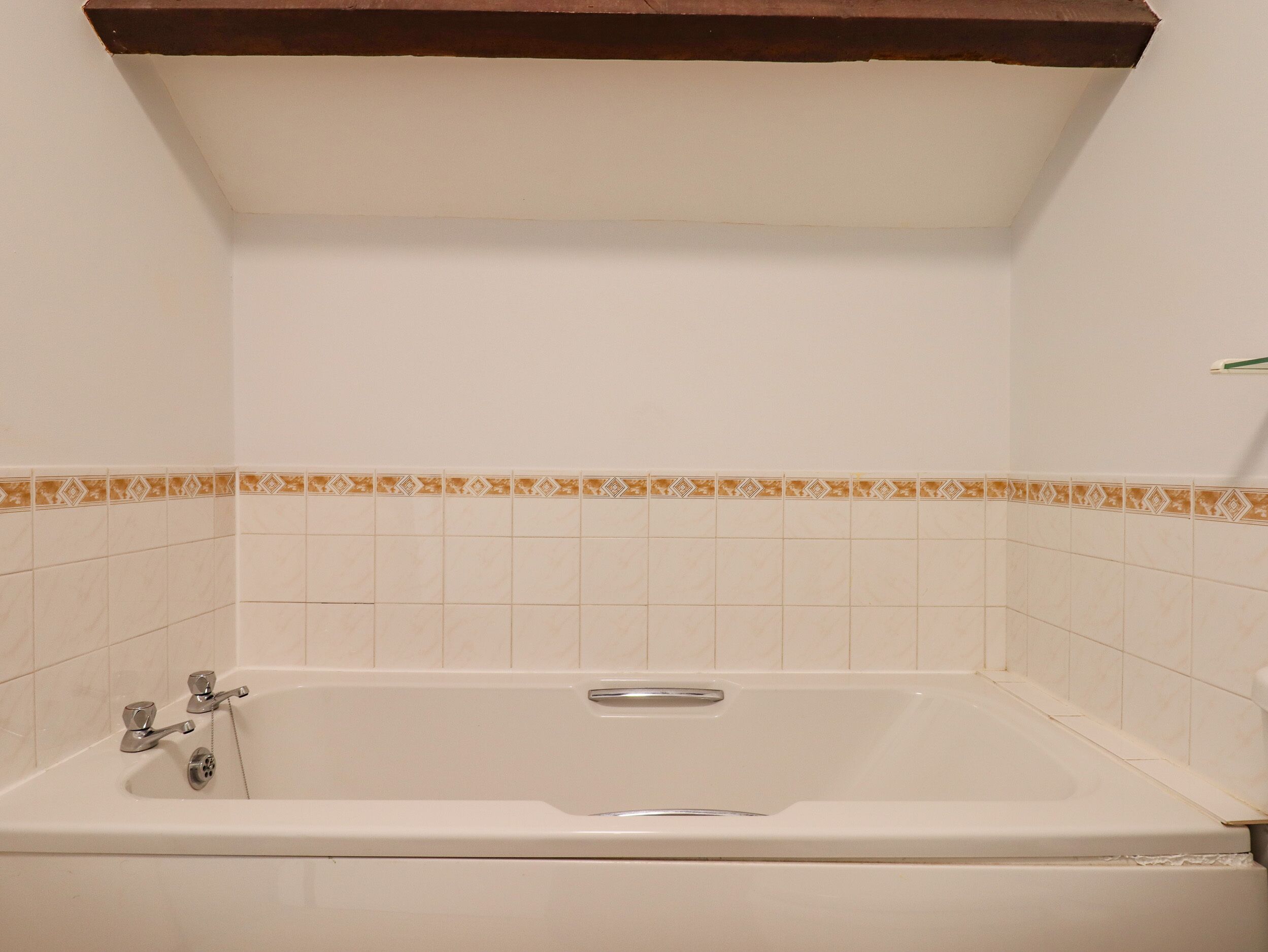A bathroom with a white bathtub, a shower, and a towel rack.