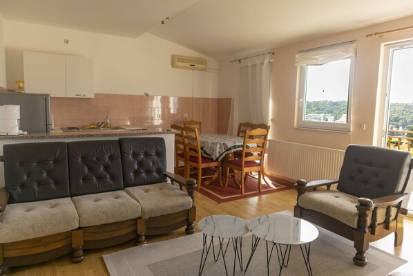 A living room with a sofa, armchairs, and a dining table. - Apartments Marija (Makarska)