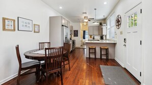 A modern kitchen with a central island, wooden dining table, and chairs. - 3 Bedroom Home in the Heart of New Orleans! (New Orleans)