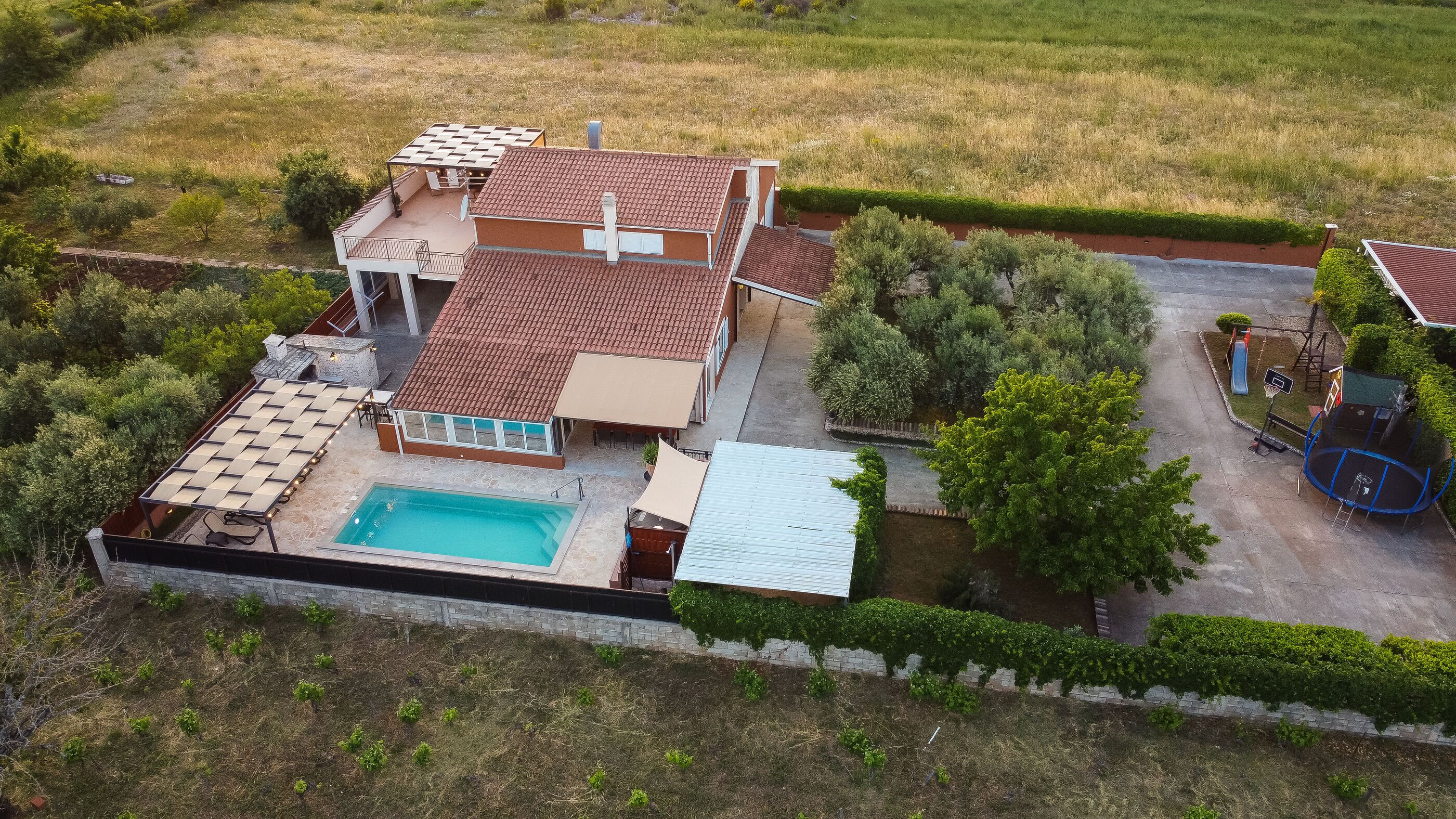 Une maison avec une piscine, une terrasse et un jardin.