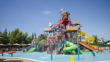 Un parque acuático con un tobogán gigante, una piscina de olas y un cartel que dice 'Solaris Aquapark'.