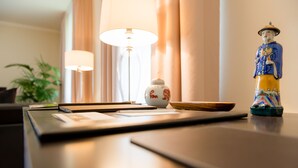 Un bureau bien rangé, avec une lampe, une tasse en céramique et une figurine décorative.