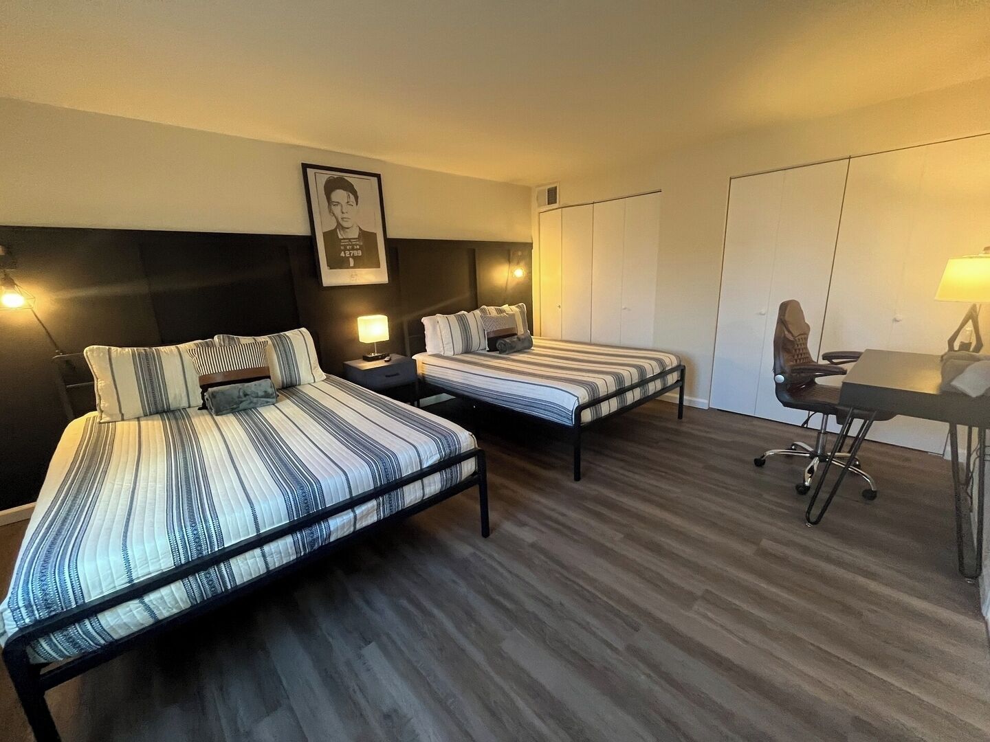 Une chambre d’hôtel avec deux lits, un bureau et une chaise.