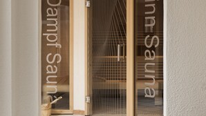 A spa entrance with a glass door, a wooden bucket, and a metal railing. - Medrazerhof (Fulpmes)