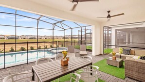 A balcony with a pool, outdoor seating, and a view of distant buildings.
